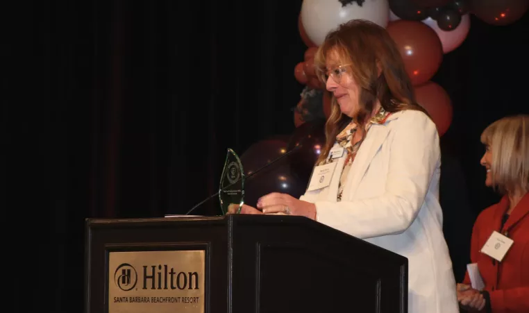 Margo at podium at Community Dividends Awards