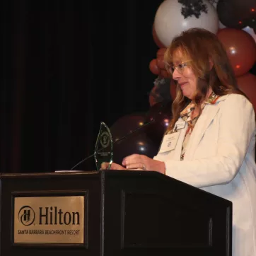 Margo at podium at Community Dividends Awards